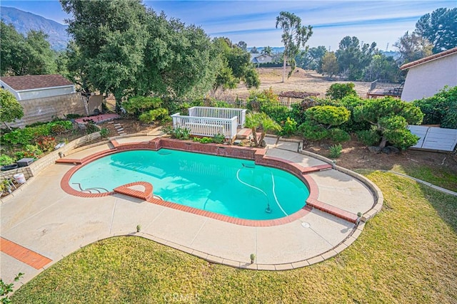 view of swimming pool featuring a mountain view, a patio area, and a lawn