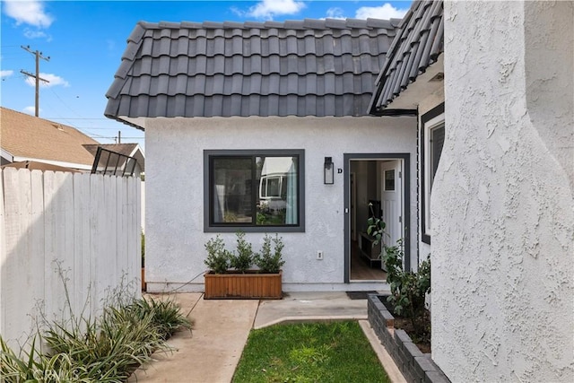 view of exterior entry with a patio