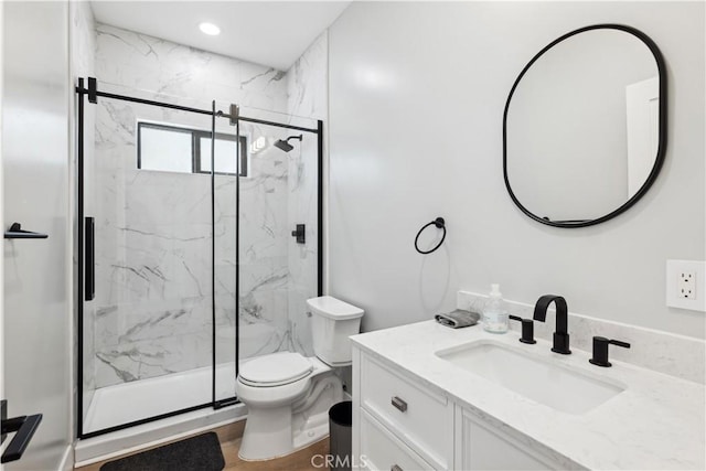 bathroom with vanity, a shower with shower door, toilet, and wood-type flooring