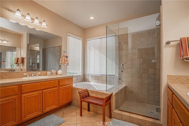 bathroom with tile patterned flooring, vanity, and shower with separate bathtub