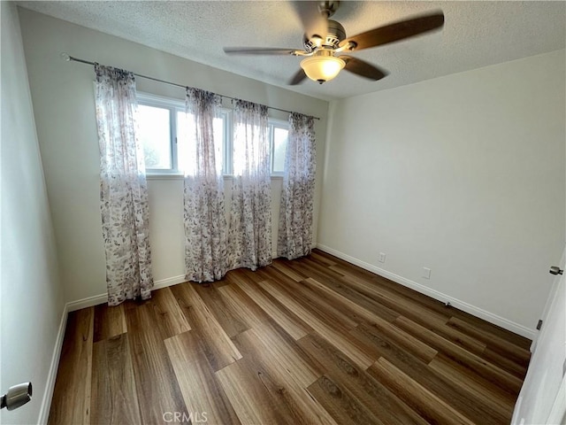 spare room with ceiling fan, hardwood / wood-style floors, and a textured ceiling