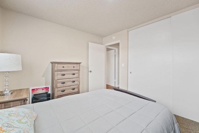 carpeted bedroom featuring a closet and a textured ceiling