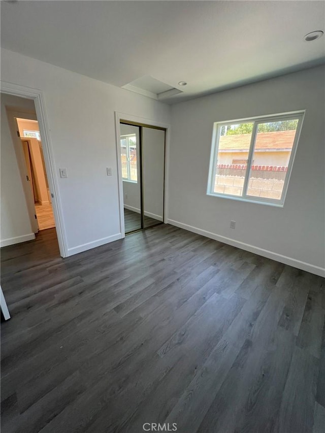 unfurnished bedroom featuring dark hardwood / wood-style floors and a closet