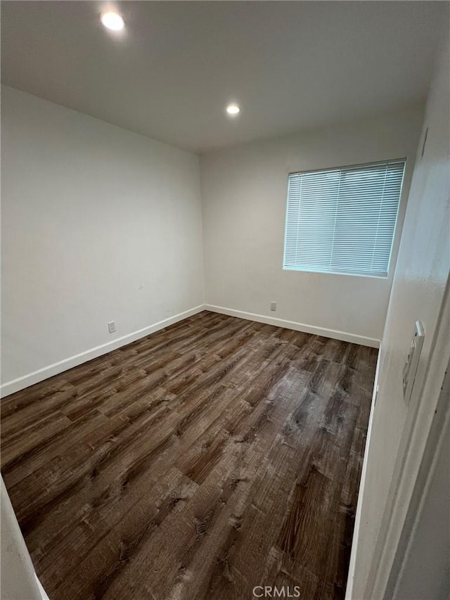 unfurnished room with dark hardwood / wood-style flooring