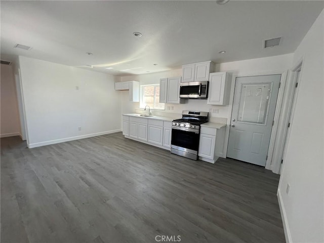 kitchen with appliances with stainless steel finishes, sink, light wood-type flooring, and white cabinets