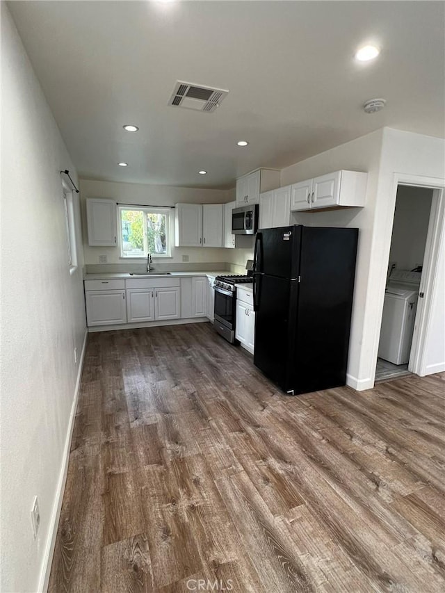 kitchen with sink, dark hardwood / wood-style floors, white cabinets, and appliances with stainless steel finishes