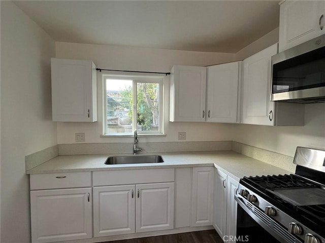 kitchen with white cabinetry, stainless steel appliances, and sink