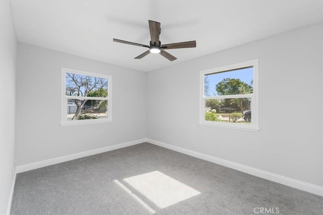 unfurnished room with ceiling fan and carpet