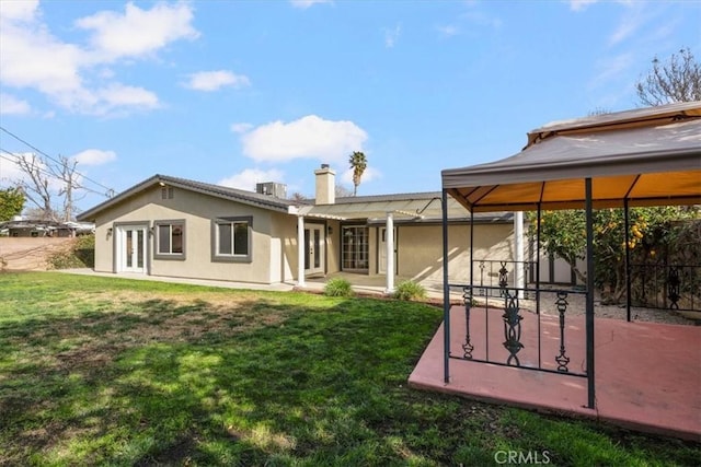 rear view of house with a gazebo, a lawn, and a patio