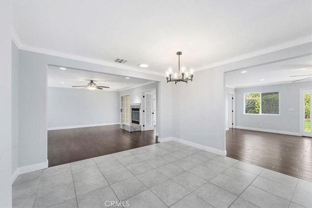 spare room with ornamental molding, ceiling fan with notable chandelier, and light wood-type flooring