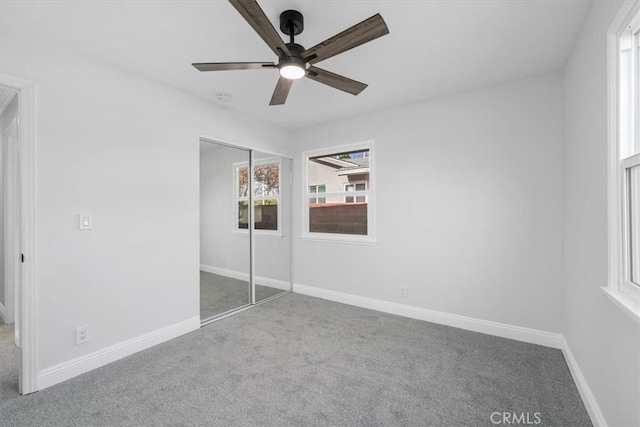 unfurnished bedroom with carpet flooring, ceiling fan, and a closet