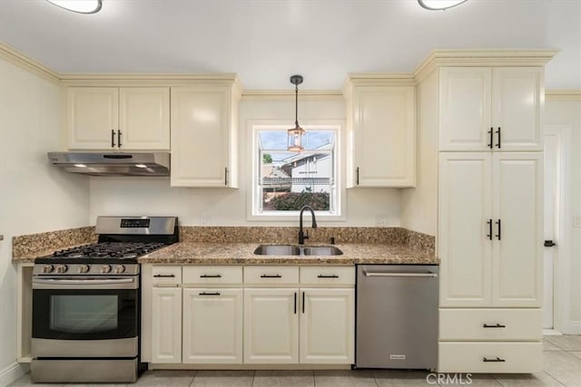 kitchen featuring sink, stone countertops, hanging light fixtures, appliances with stainless steel finishes, and cream cabinets