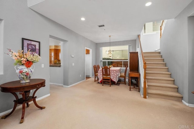 carpeted dining room featuring a notable chandelier