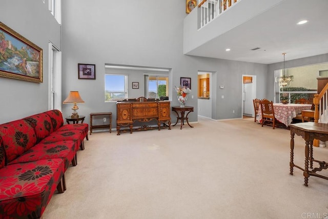 living room featuring a notable chandelier, carpet floors, and a high ceiling