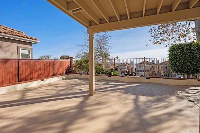 view of patio featuring fence and a residential view