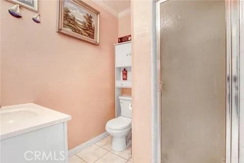 bathroom featuring crown molding, toilet, tile patterned floors, and walk in shower