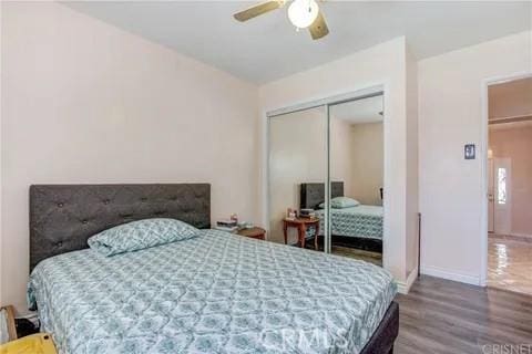 bedroom with ceiling fan, hardwood / wood-style floors, and a closet