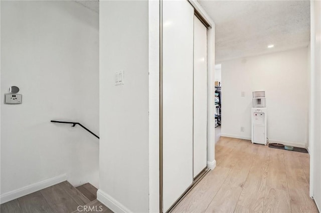 corridor with light hardwood / wood-style flooring