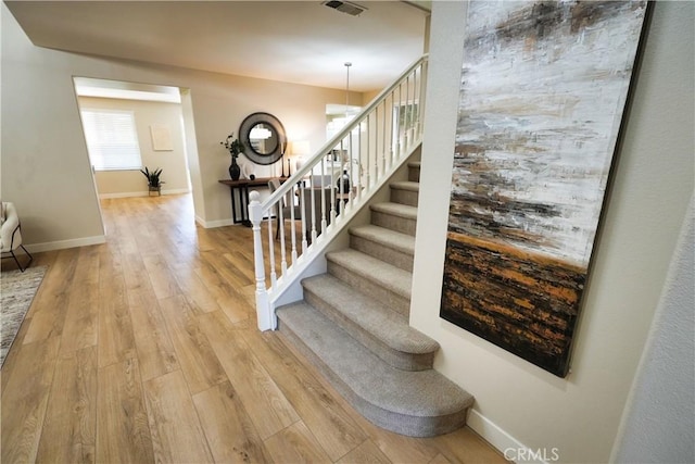 stairs featuring hardwood / wood-style floors