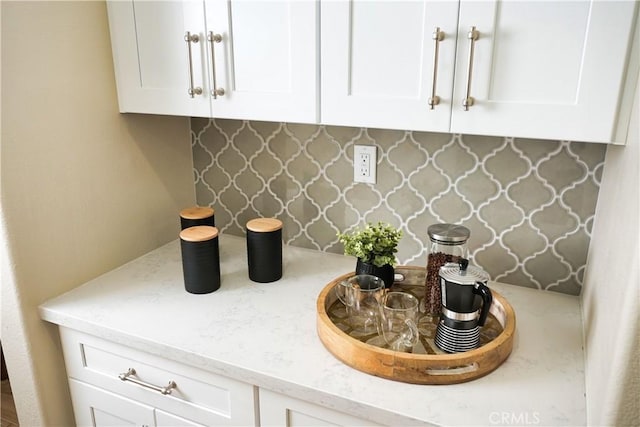 interior space with white cabinets and light stone counters