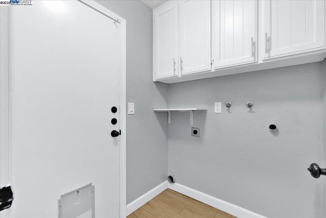 laundry area with gas dryer hookup, cabinets, hookup for a washing machine, electric dryer hookup, and light hardwood / wood-style floors