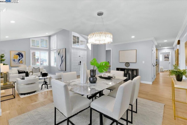 dining room featuring ornamental molding, lofted ceiling, a notable chandelier, and light wood-type flooring