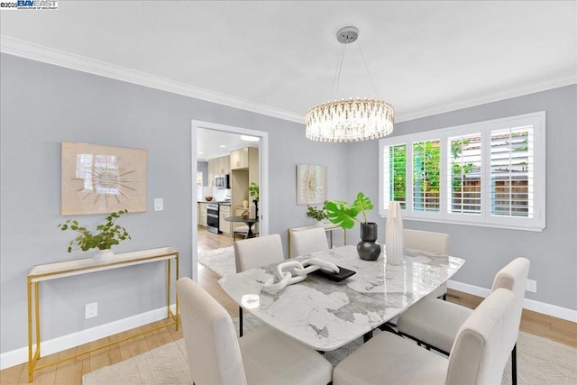 dining room featuring ornamental molding, a notable chandelier, and light wood-type flooring