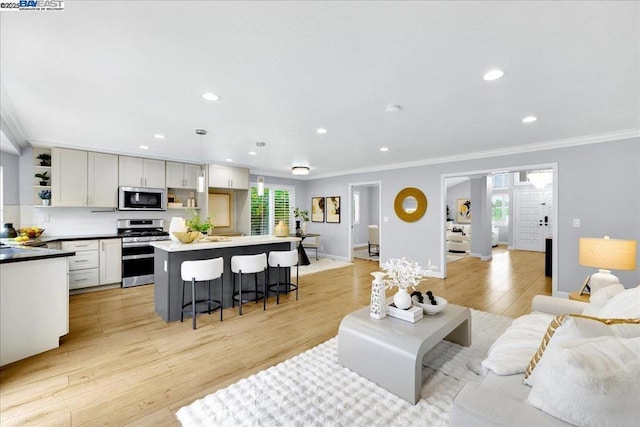 living room with ornamental molding and light wood-type flooring