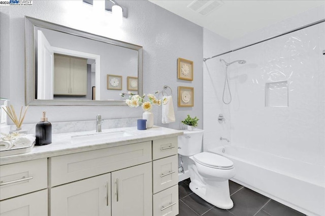 full bathroom with tiled shower / bath, tile patterned floors, toilet, and vanity