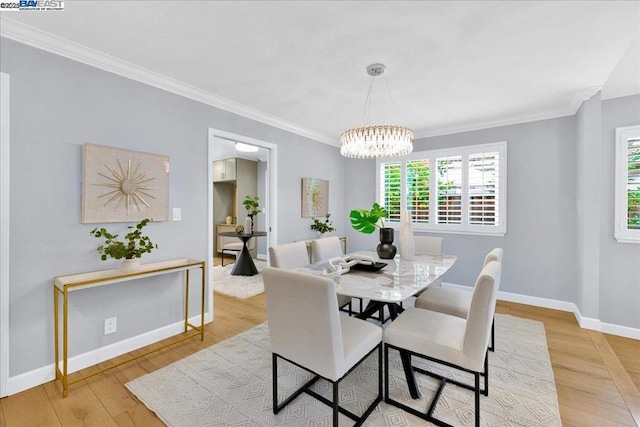 dining area featuring a notable chandelier, crown molding, and light hardwood / wood-style floors