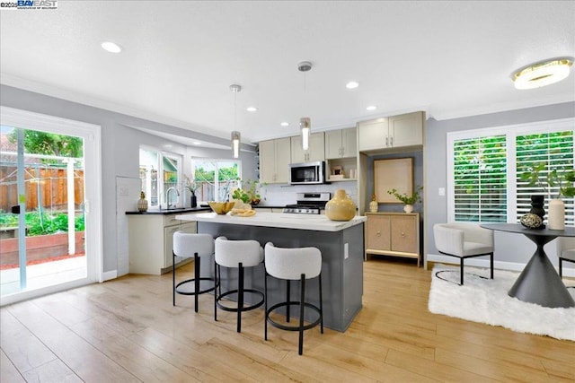 kitchen featuring stainless steel appliances, ornamental molding, hanging light fixtures, and gray cabinetry