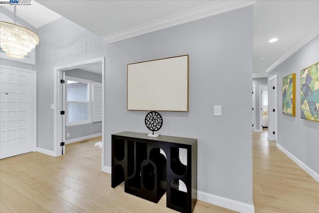 entryway featuring crown molding, a chandelier, and light hardwood / wood-style flooring