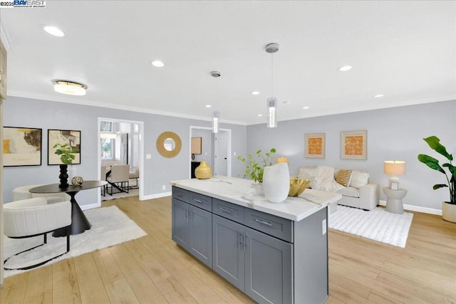 kitchen featuring crown molding, pendant lighting, and light wood-type flooring