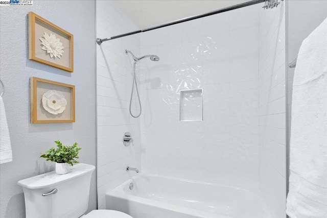 bathroom featuring tiled shower / bath and toilet