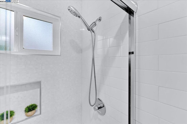 bathroom featuring plenty of natural light and tiled shower