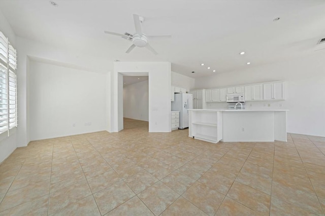 unfurnished living room featuring sink, ceiling fan, and light tile patterned flooring