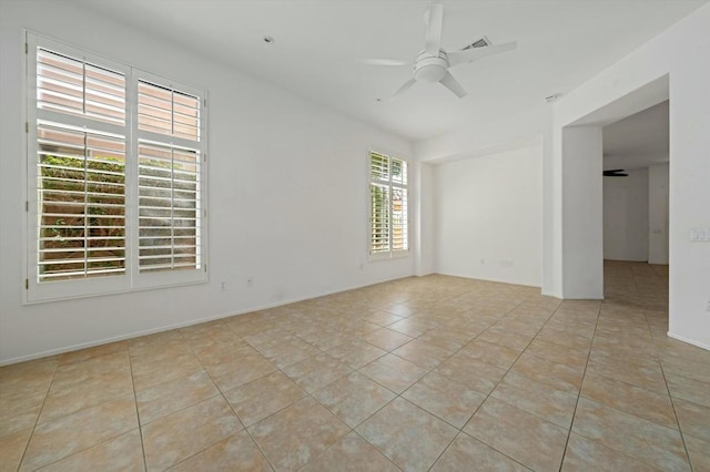 tiled spare room with ceiling fan