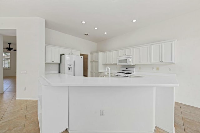 kitchen featuring light tile patterned floors, white cabinets, and white appliances