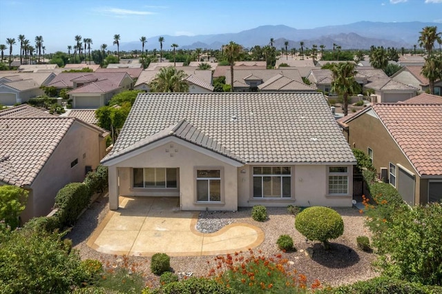 back of house featuring a mountain view and a patio