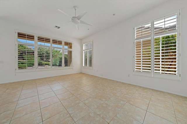 tiled spare room with ceiling fan