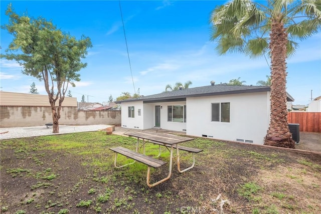 back of property featuring a yard, stucco siding, a patio area, cooling unit, and a fenced backyard