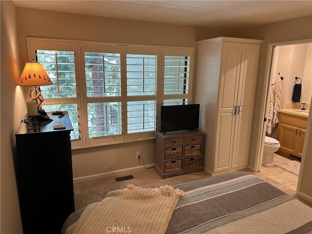 bedroom with connected bathroom and sink