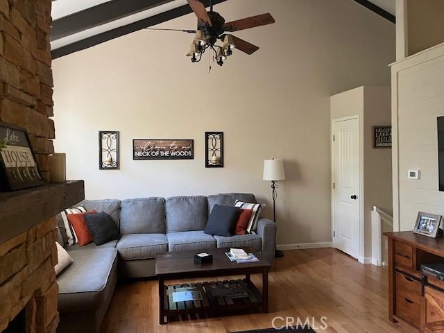 living room featuring beam ceiling, hardwood / wood-style flooring, high vaulted ceiling, and ceiling fan