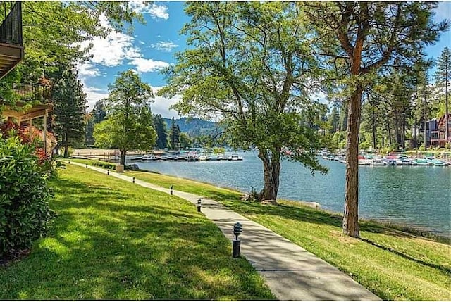 view of home's community featuring a water view and a lawn