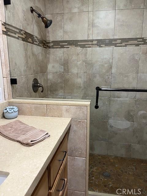 bathroom featuring vanity and tiled shower