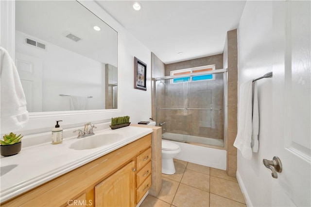 full bathroom featuring tile patterned flooring, vanity, toilet, and combined bath / shower with glass door