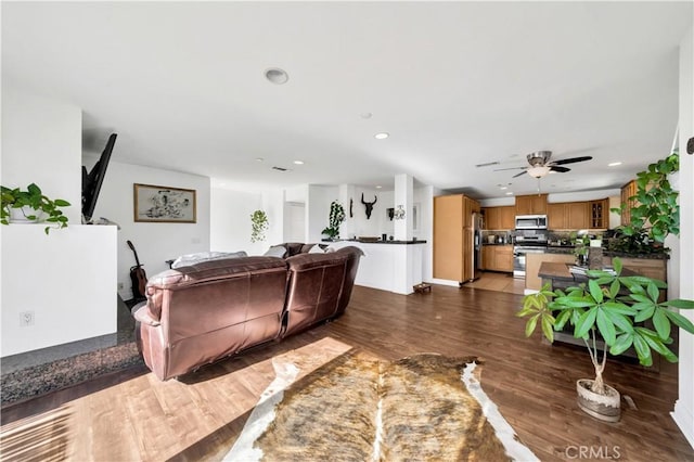 living room with ceiling fan and dark hardwood / wood-style floors