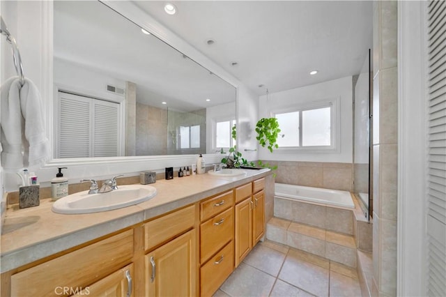 bathroom with vanity, tile patterned floors, and plus walk in shower