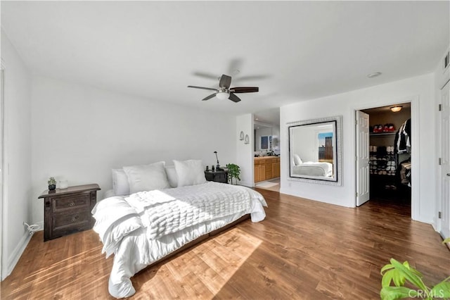 bedroom featuring ensuite bath, dark hardwood / wood-style floors, ceiling fan, and a closet