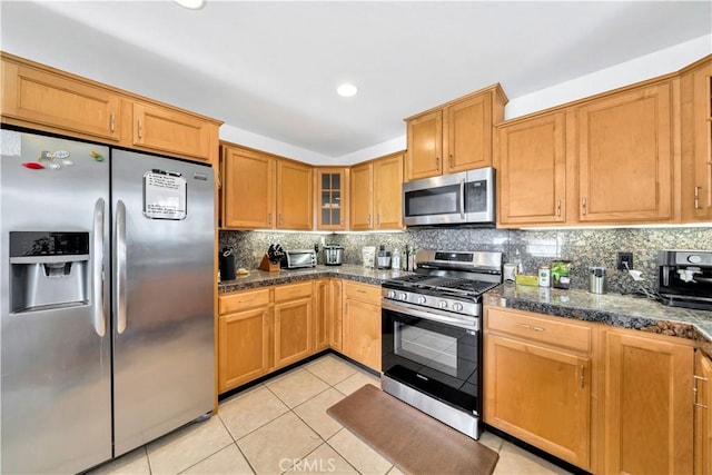 kitchen featuring light tile patterned floors, decorative backsplash, and appliances with stainless steel finishes